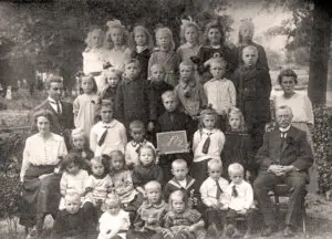 Groepsportret no. 2 van leerlingen en onderwijzend personeel van de openbare lagere school te Lutten aan de Dedemsvaart. Links juf Jo Reinink met achter haar meester Pieter van der Mei. Rechts hoofdonderwijzer Hendrik Lanting en juf Betsy Rodink.