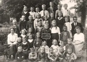 Groepsportret no. 3 van leerlingen en onderwijzend personeel van de openbare lagere school te Lutten aan de Dedemsvaart. Links juf Jo Reinink met achter haar hoofdonderwijzer Hendrik Lanting. Rechts juf Betsy Rodink en achter haar meester Pieter van der Mei.