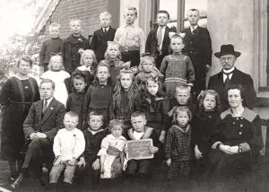 Groepsportret no. 3 van leerlingen en onderwijzend personeel van de openbare lagere school te Lutten aan de Dedemsvaart. Links staat juf E. Rodink; naast haar zit meester J. Smit. Rechts zit juf J. Reinink en achter haar het hoofd van de school, H. Lanting.