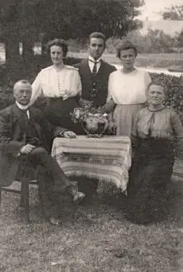 Kabinet-portret van het onderwijzend personeel van de openbare lagere school te Lutten aan de Dedemsvaart, gemaakt in de tuin bij het meestershuis, met v.l.n.r.: hoofdonderwijzer Hendrik Lanting, onderwijzeres Johanna Reinink, onderwijzer Pieter van der Mei, onderwijzeres Elisabeth Rodink en de echtgenote van de hoofdonderwijzer: Jentje Lanting-Prangsma.