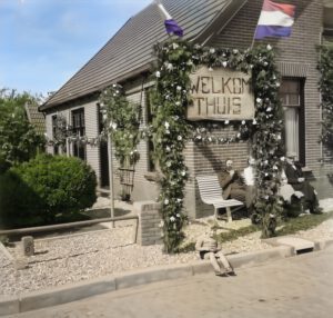 In afwachting van Jan Gerrit Ballast, die terugkeert uit Nederlands -Indië. Op de stoeprand Jantje Lägers, op de bank van v.l.n.r. Luite Ballast, Fetsje Ballast, Johanna Reinink en Jan Reinink
