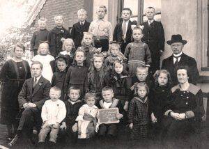 Groepsportret no. 3 van leerlingen en onderwijzend personeel van de openbare lagere school te Lutten aan de Dedemsvaart. Links staat juf E. Rodink; naast haar zit meester J. Smit. Rechts zit juf J. Reinink en achter haar het hoofd van de school, H. Lanting.