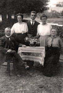 Kabinet-portret van het onderwijzend personeel van de openbare lagere school te Lutten aan de Dedemsvaart, gemaakt in de tuin bij het meestershuis, met v.l.n.r.: hoofdonderwijzer Hendrik Lanting, onderwijzeres Johanna Reinink, onderwijzer Pieter van der Mei, onderwijzeres Elisabeth Rodink en de echtgenote van de hoofdonderwijzer: Jentje Lanting-Prangsma.